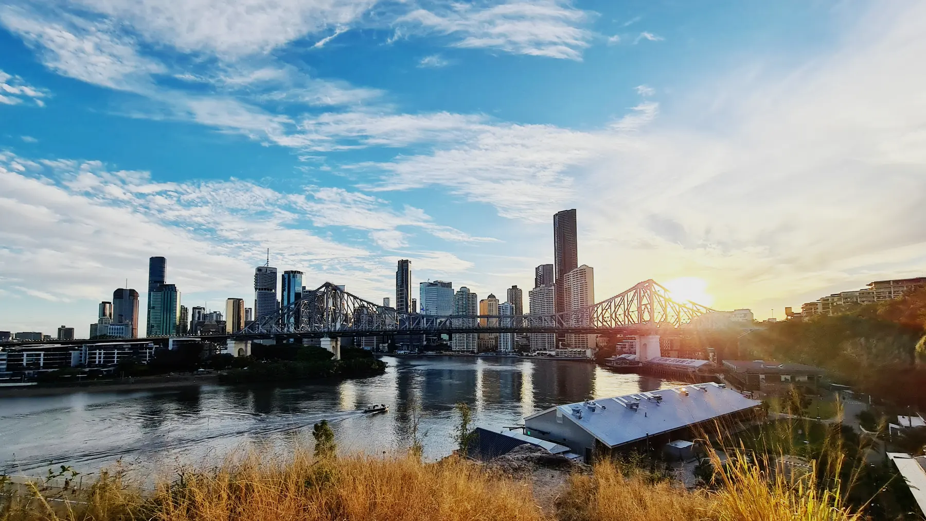 The Brisbane skyline and the Story Bridge at sunset, seen across the river.