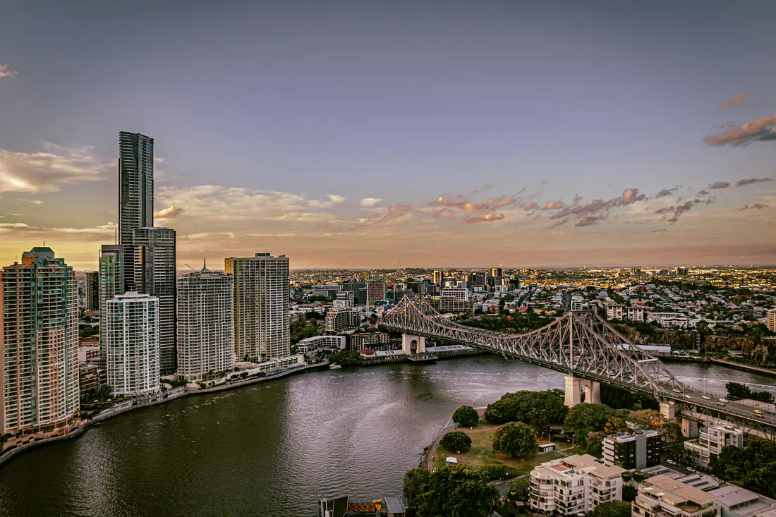 The Brisbane River winding past high-rise apartments towards the Story Bridge.