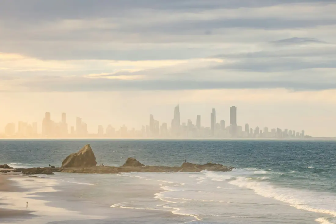 The Gold Coast skyline seen along the beach on a hazy evening.