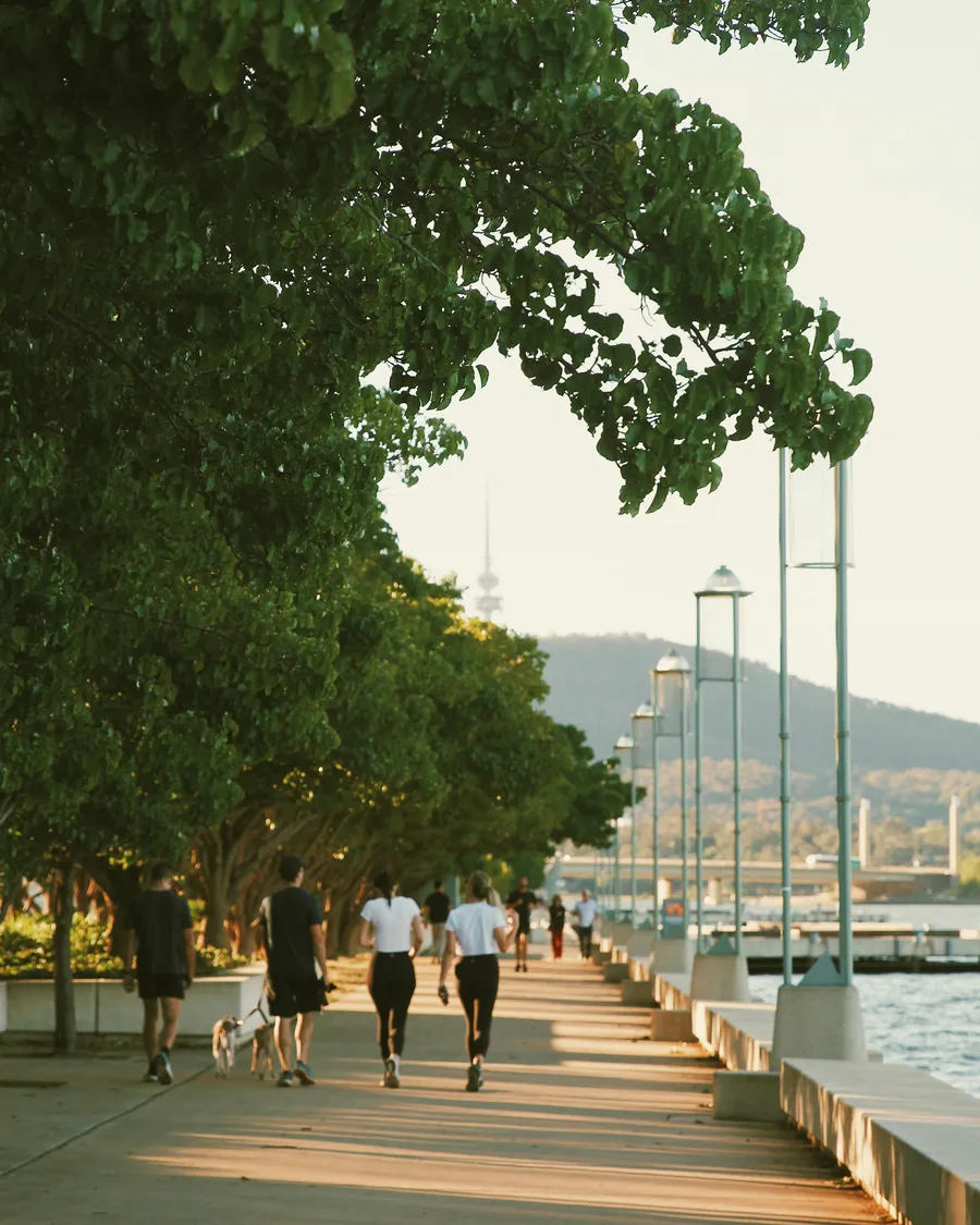 People walking along the foreshore path beside Lake Burley Griffin, Canberra.